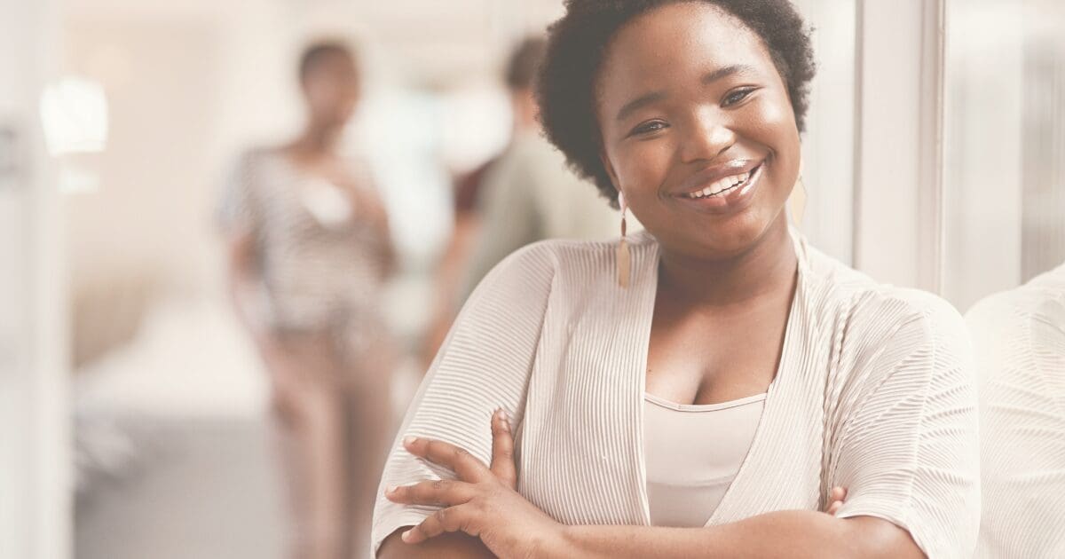 A woman smiling warmly, at peace with who she is, for the Prayer & Perspective devotional "Remember Who You Are"