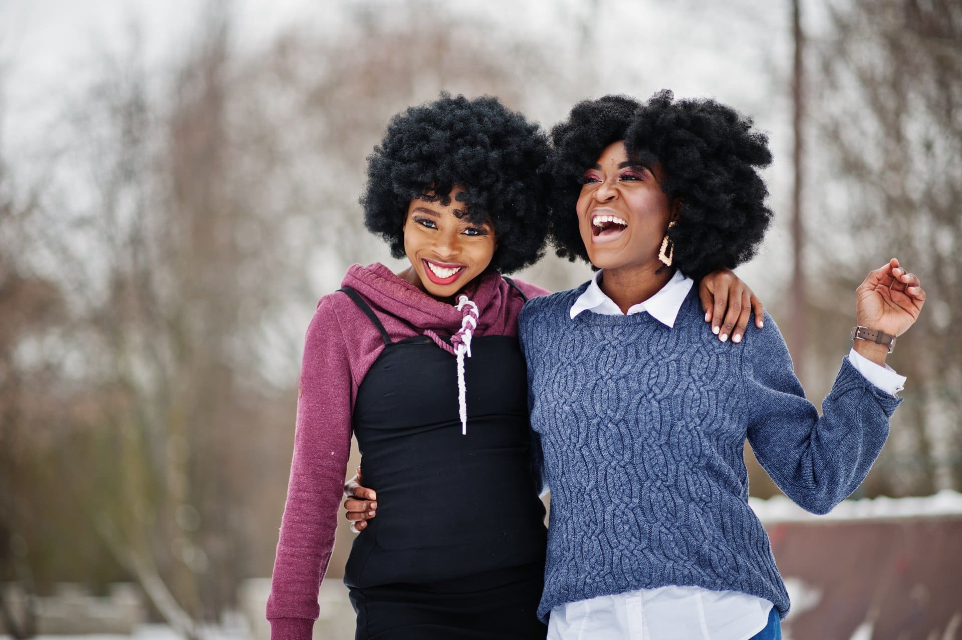 Two women laughing together during an outdoor walk.